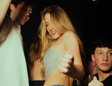 Ragazza bionda balla in mezzo alla folla