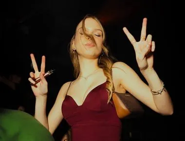 Ragazza in rosso fa il segno della pace con entrambe le mani