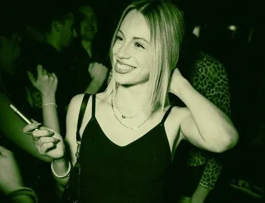 Ragazza bionda sorride sotto una luce verde