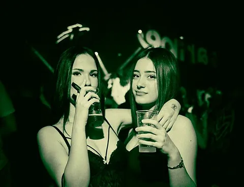Due amiche con i drink in mano, scatto dai toni verdi