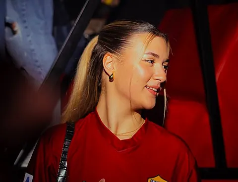 Ragazza in maglia rossa sorride in pista