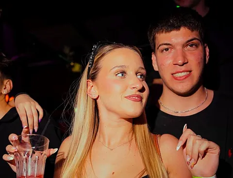 Coppia sorridente con un drink rosa